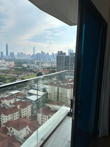 une porte ouverte s'ouvrant sur un balcon offrant une vue sur la ville. dans l'établissement Reizz Residence by Perkasa, à Kuala Lumpur