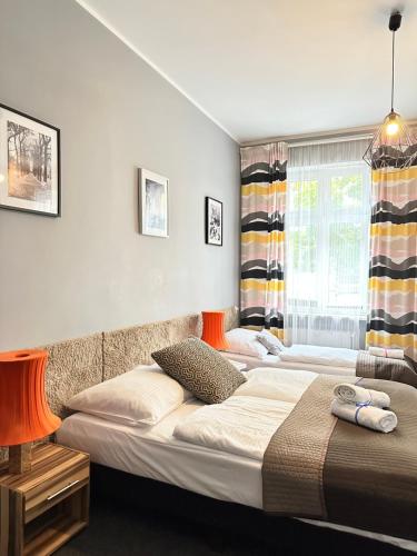 a bedroom with two beds and a window at Expolis Residence - City Center MTP TARGI- Reception 24h in Poznań