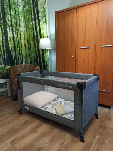 a blue crib in a room with trees in the background at Apartament ROZETA centrum 6os in Legnica