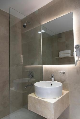 a bathroom with a sink and a glass shower at H5063 in Buenos Aires
