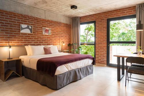 een slaapkamer met een bed en een bakstenen muur bij H5063 in Buenos Aires