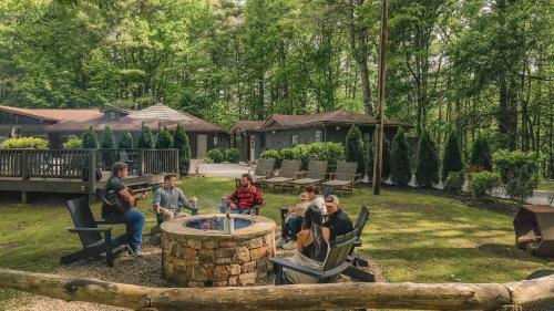 a group of people sitting around a fire pit in a yard at Hotel Cashiers in Cashiers