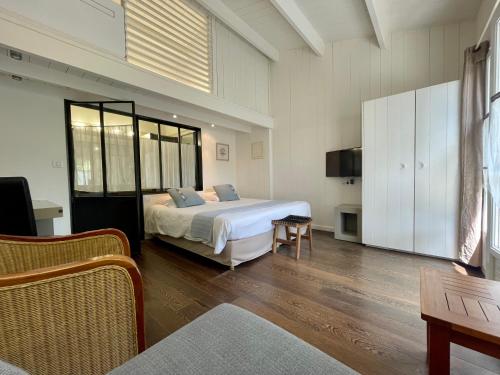 - une chambre avec un lit et une télévision dans l'établissement La Villa - Hôtel Bien Être, au Bois-Plage-en-Ré