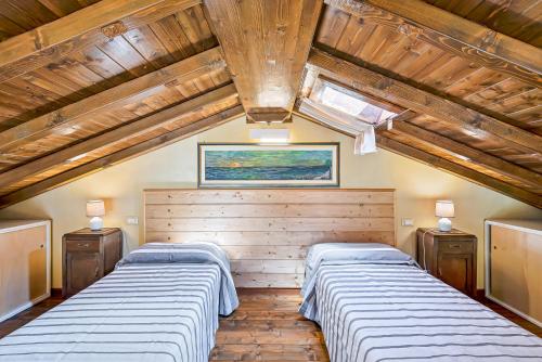 2 Betten in einem Zimmer mit Holzdecken in der Unterkunft Casa vacanze Ester in Polverara
