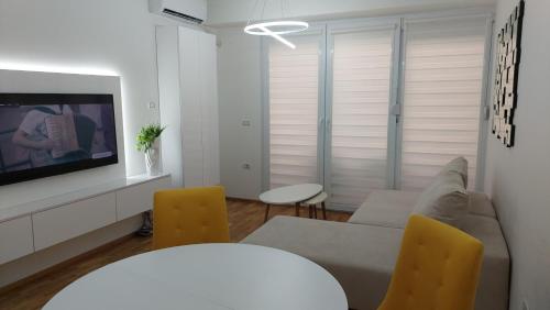 a living room with a couch and yellow chairs at Luxury Apartment Nika in Ohrid