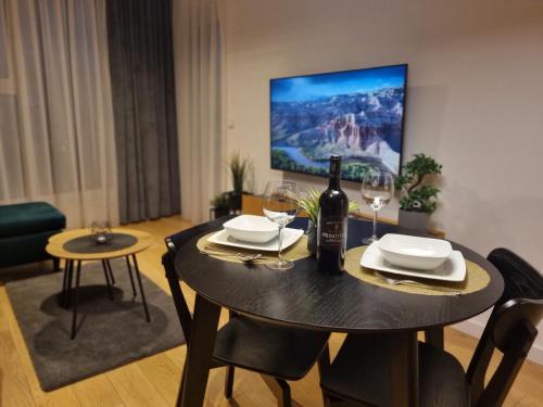 stół jadalny z butelką wina i kieliszkami w obiekcie Premium Apartments Rzeszów Gold w mieście Rzeszów