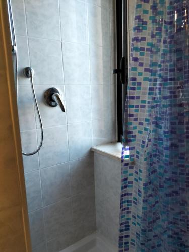 薩薩里的住宿－casa di Carlo e Chiara，浴室设有马赛克瓷砖和墙壁上的淋浴。
