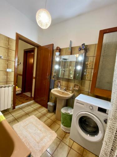 a bathroom with a washing machine and a sink at Villa Maria - Sant'Angelo di Brolo in SantʼAngelo di Brolo