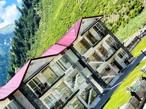 a building with a pink roof on a mountain at Kunhar Hotel RiverSide Block in Nārān