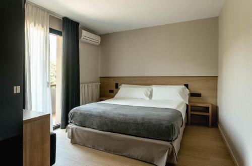 um quarto com uma cama e uma grande janela em Hotel Terradets em Cellers