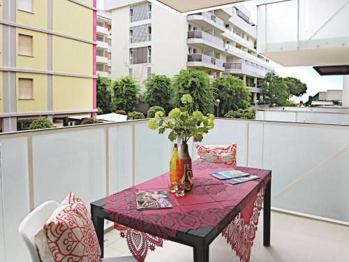 una mesa con un jarrón de flores en el balcón en Residence Green Life, en Bibione