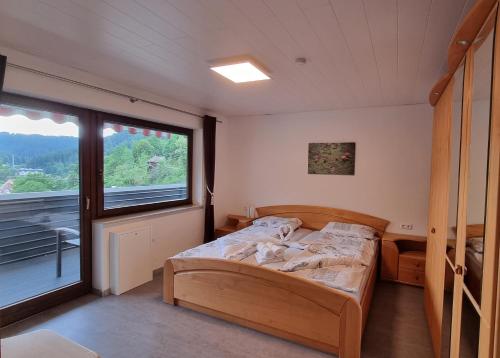 a bedroom with a bed and a large window at Haus Erika Ferienwohnung 1 in Bad Teinach-Zavelstein