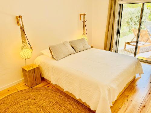 a bedroom with a white bed with a window at Salema Eco Camp - Sustainable Camping & Glamping in Salema