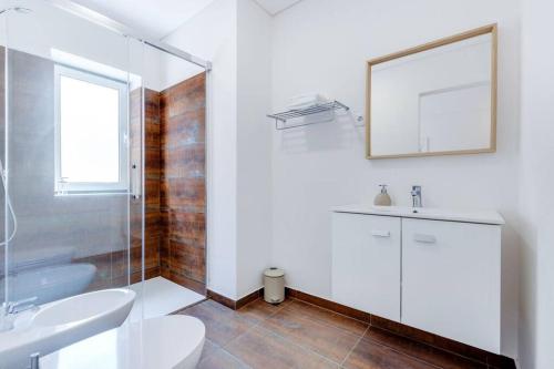 a bathroom with a sink and a toilet and a mirror at Casa D'Areia a 1 km da Praia. in Vila Praia de Âncora