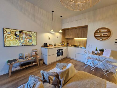 une cuisine et un salon avec une table et des chaises dans l'établissement Arcarêve - Grand Studio Deluxe avec terrasse, jardin et accès plage, à Arcachon