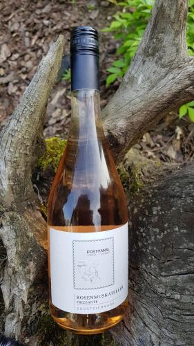 a bottle of wine sitting on a tree branch at Posthansl l Sernau 1 in Gamlitz