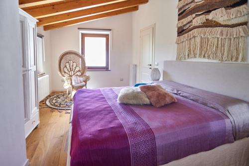 sypialnia z łóżkiem z fioletowym kocem w obiekcie L'Oasi nel Borgo w mieście Monteroduni