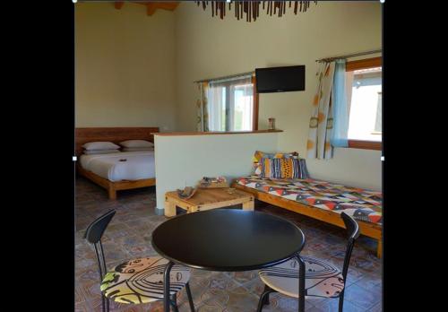 una habitación con una mesa y sillas y una cama en Pension Gabino (rooms), en El Ganso