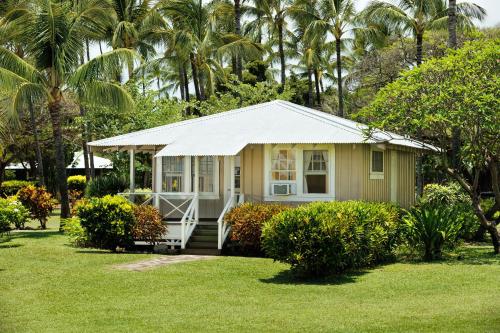 a small house in a yard with palm trees at Waimea Plantation Cottages, a Coast Resort in Waimea