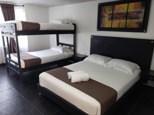 a room with two bunk beds and a painting on the wall at Hotel Casa Galeras in Pasto