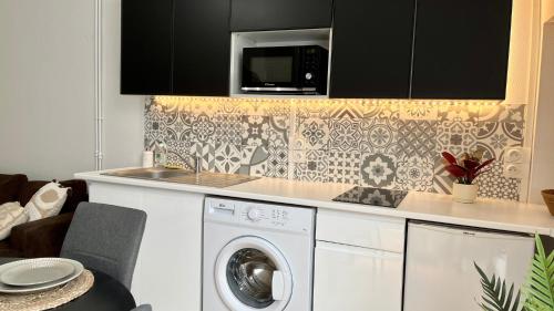 een keuken met een wasmachine en een magnetron bij La Porte des rêves in Nevers