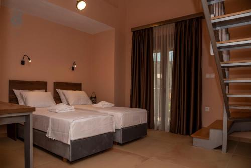 a bedroom with two beds and a book shelf at Old Nikiti's Hotel in Nikiti