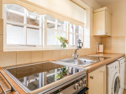 uma cozinha com um lavatório e uma janela em Redwood Cottage em Covington