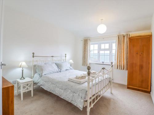 een slaapkamer met een wit bed en een raam bij Redwood Cottage in Covington