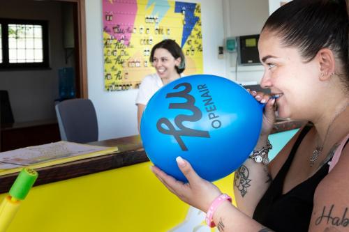 a woman is holding a blue balloon with a dollar sign on it at hu I Pini village in Fiano Romano