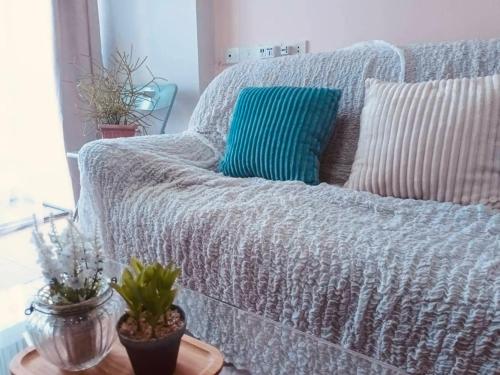 a gray couch with a blue pillow on a table at Cozy 1br walk to BTS and Airport Rail Link Close to Malls T in Bangkok