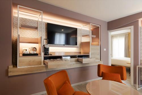 uma sala de estar com uma televisão e uma mesa de vidro em Adesso Hotel em Roma