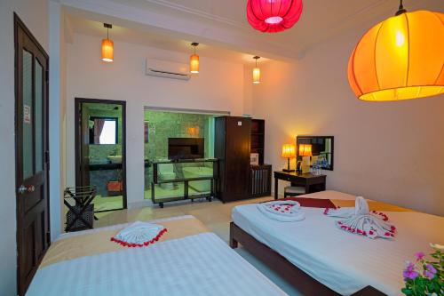 een slaapkamer met 2 bedden en een woonkamer bij The House 36 in Hội An