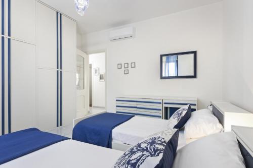 a white bedroom with two beds and a mirror at Casa Giovanna by Wonderful Italy in Bari