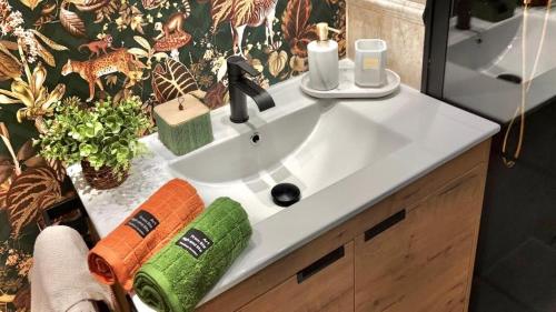 a bathroom sink with a green and orange towel at MAD SUITE Aeropuerto IFEMA in Madrid