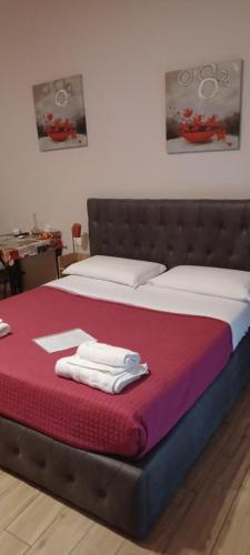 una camera da letto con un letto e asciugamani di Emmanueli65 fronte clinica per 4 matrimoniale e castello a Piacenza