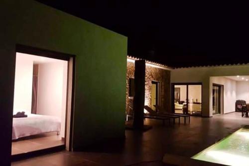 Cette chambre comprend un lit et un mur vert. dans l'établissement Villa élégante à Porto-Vecchio avec piscine privée, à Porto-Vecchio