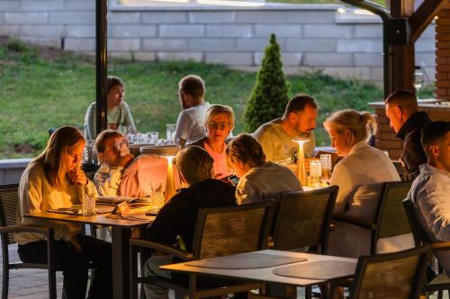 a group of people sitting at tables in a restaurant at Grand Lakes Rooms in Plitvička Jezera