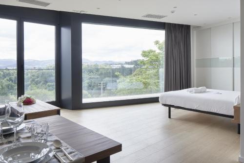 een slaapkamer met een bed en een groot raam bij MANTULENE Apartments - Basque Stay in San Sebastian