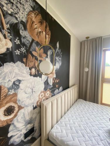 een slaapkamer met een muurschildering van bloemen op de muur bij Apartament PORTO in Gdańsk