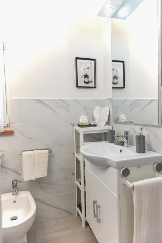 a white bathroom with a sink and a toilet at Kododo in Tuscany Lucca in Lucca