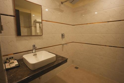 a bathroom with a white sink and a mirror at Hotel CP Palace in Patna