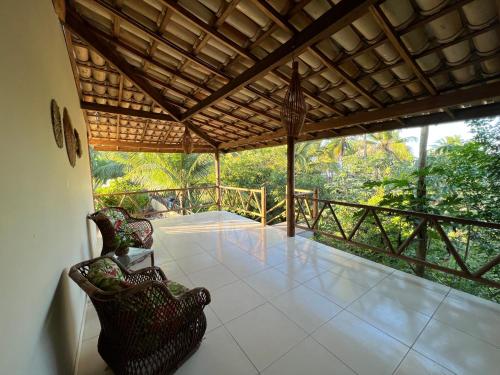 a room with two chairs and a balcony with trees at Pousada Oceano Atlântico in Marau