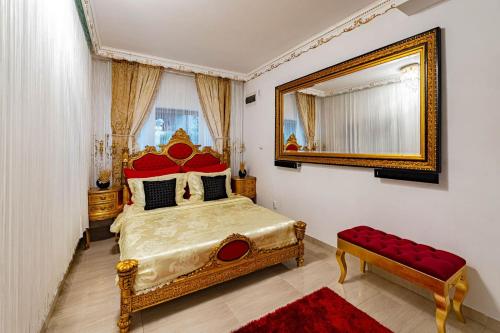 a bedroom with a large bed and a mirror at Negrean Residence in Oradea