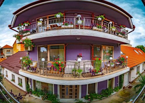 - une maison ronde avec des fleurs sur le balcon dans l'établissement Negrean Residence, à Oradea