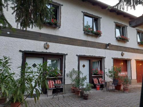 a building with chairs and plants in front of it at Pension Welserhof in Wilfersdorf