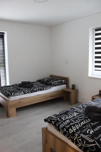 2 camas en una habitación con 2 ventanas en Apart U Svatých en Halenkovice