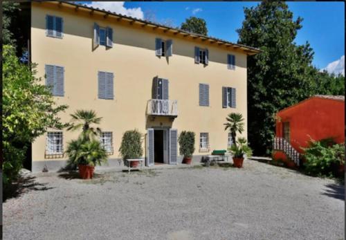 una casa grande con un gran patio delante en Villa Marilu, en Capannori