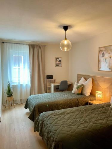 a hotel room with two beds and a desk and a window at Visit Oberhof 3 in Oberhof