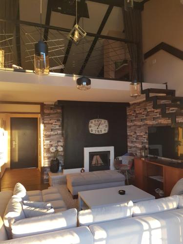 a living room with white couches and a fireplace at Sarajevo Sky View in Sarajevo
