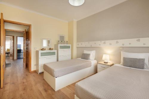 a hotel room with two beds and a bathroom at Apartamento Girassol - Minho's Guest in Braga